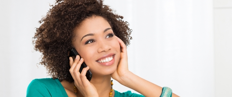 Foto de um atendente de telefone sorrindo e ajudando um cliente.