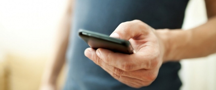 Foto de um celular com a frase "Torpedos de Voz vs SMS".