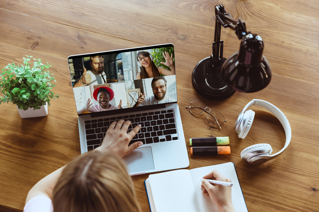 Imagem de cima mostra mulher em vídeo chamada com colegas no computador, em escritórios virtuais.